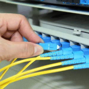 Technician installing Ethernet cables into a server rack as part of structured premises cabling setup